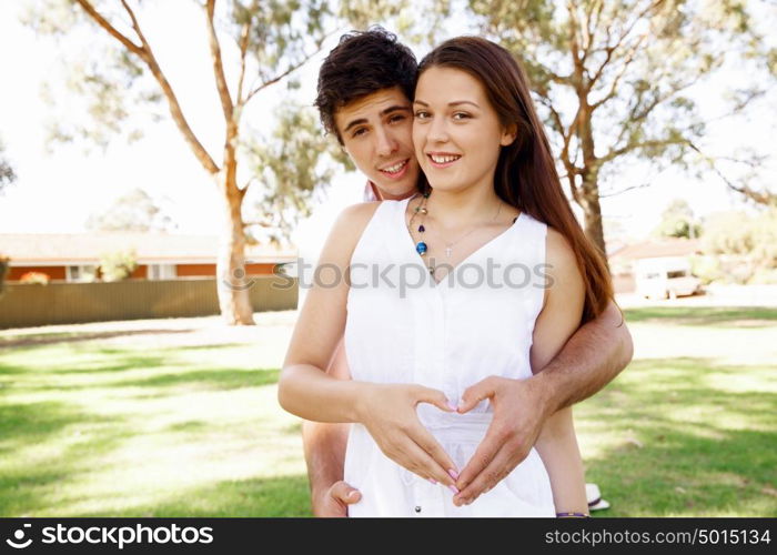 Young couple in the park. Young couple in the park and heart symbol