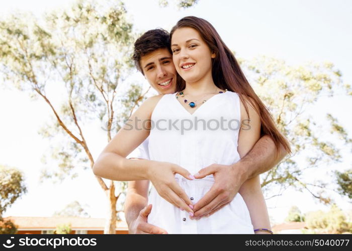 Young couple in the park. Young couple in the park and heart symbol