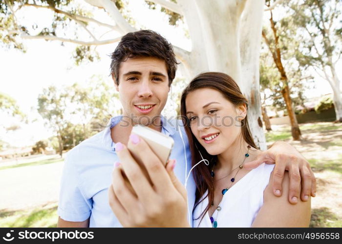 Young couple in the park. Young couple in the park making their selfi with mobile phone