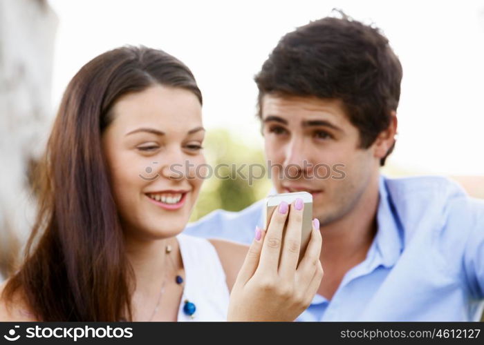 Young couple in the park. Young couple in the park with mobile phone