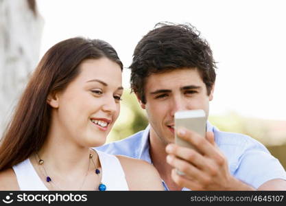 Young couple in the park. Young couple in the park with mobile phone