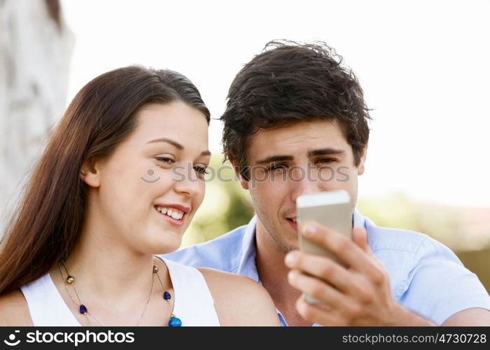 Young couple in the park. Young couple in the park with mobile phone