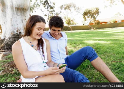 Young couple in the park. Young couple in the park with mobile phone