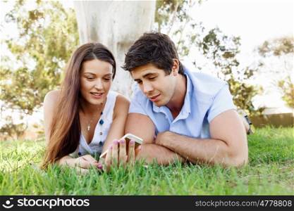 Young couple in the park. Young couple in the park with mobile phone