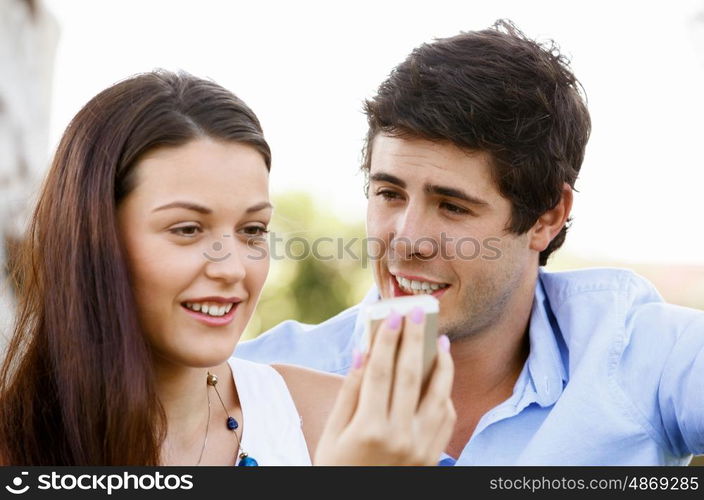 Young couple in the park. Young couple in the park with mobile phone