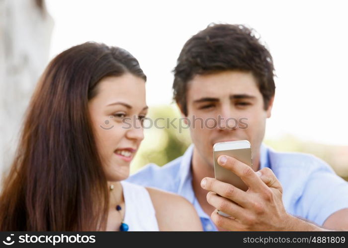 Young couple in the park. Young couple in the park with mobile phone