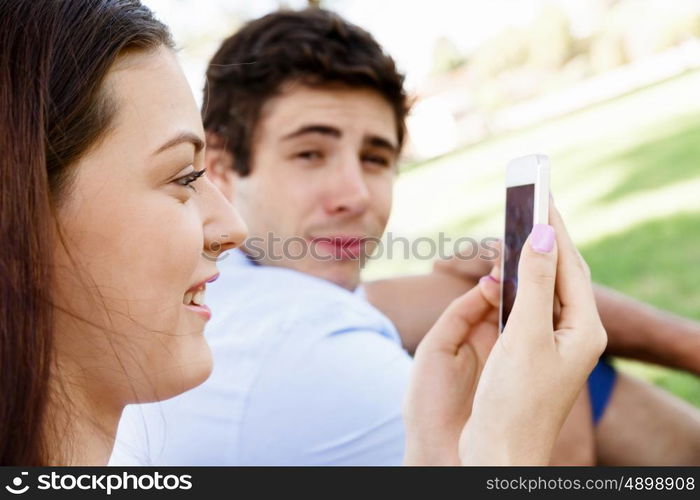 Young couple in the park. Young couple in the park with mobile phone