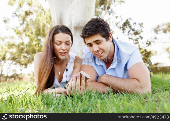 Young couple in the park. Young couple in the park with mobile phone