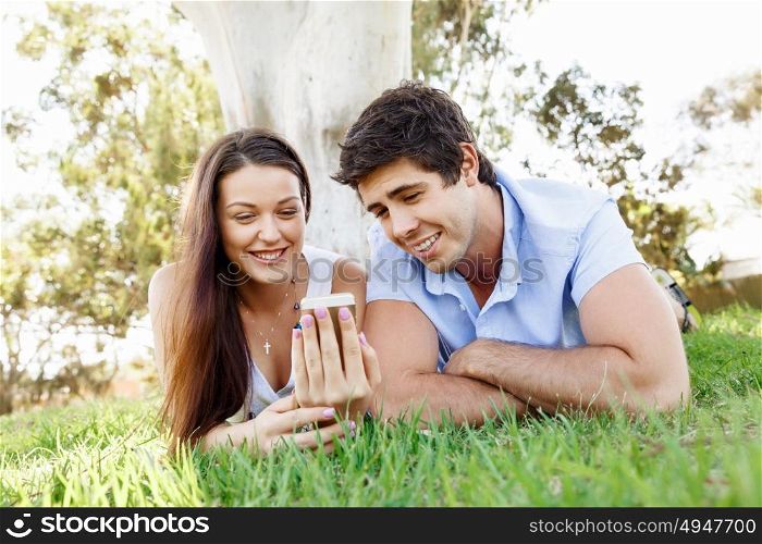 Young couple in the park. Young couple in the park with mobile phone