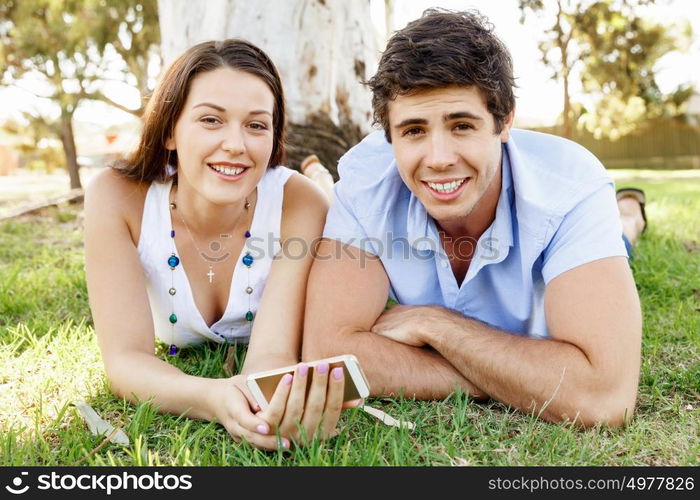 Young couple in the park. Young couple in the park with mobile phone