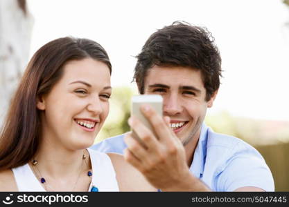 Young couple in the park. Young couple in the park with mobile phone