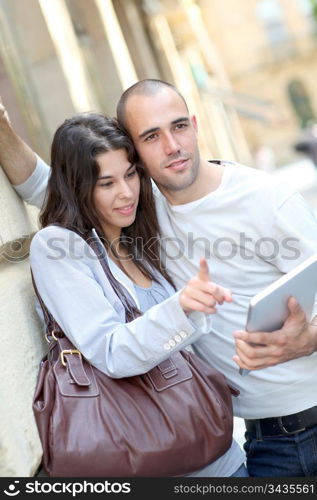 Young couple in town with electronic tablet