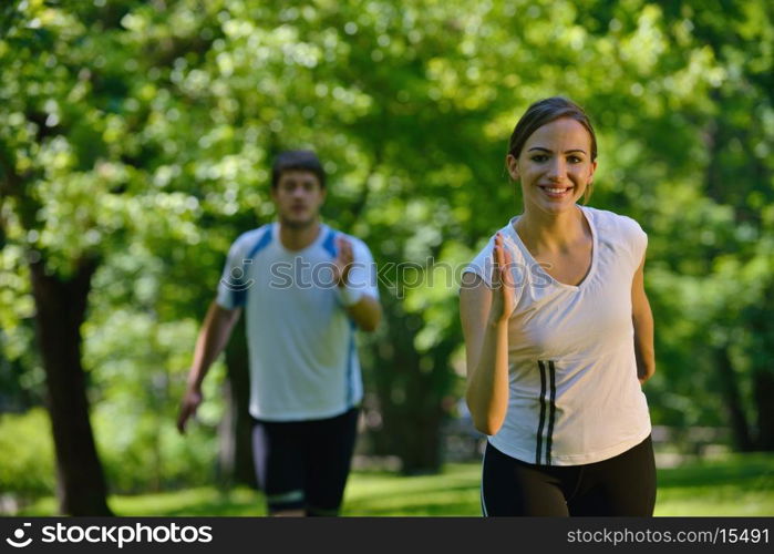 Young couple jogging in park at morning. Health and fitness.