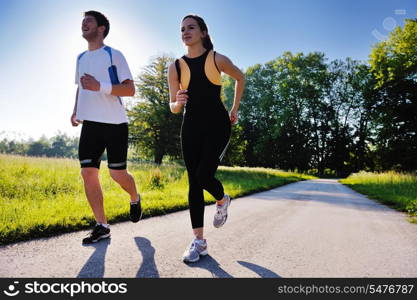 Young couple jogging in park at morning. Health and fitness.