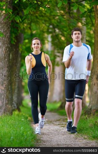 Young couple jogging in park at morning. Health and fitness.