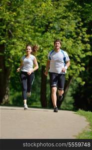 Young couple jogging in park at morning. Health and fitness concept