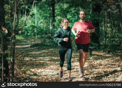 Young Couple Jogging Outdoors in Park. Nature, green background.. Young Couple Jogging, Nature, Outdoors