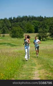 Young couple jogging outdoors in spring nature on sunny day