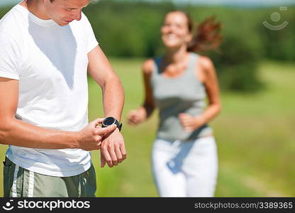 Young couple jogging outdoors in spring nature on sunny day