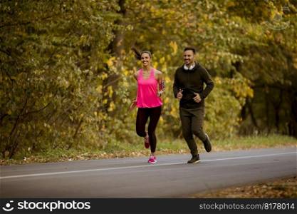 Young couple jogging together in autumn park