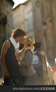 Young couple kiss in sunset street