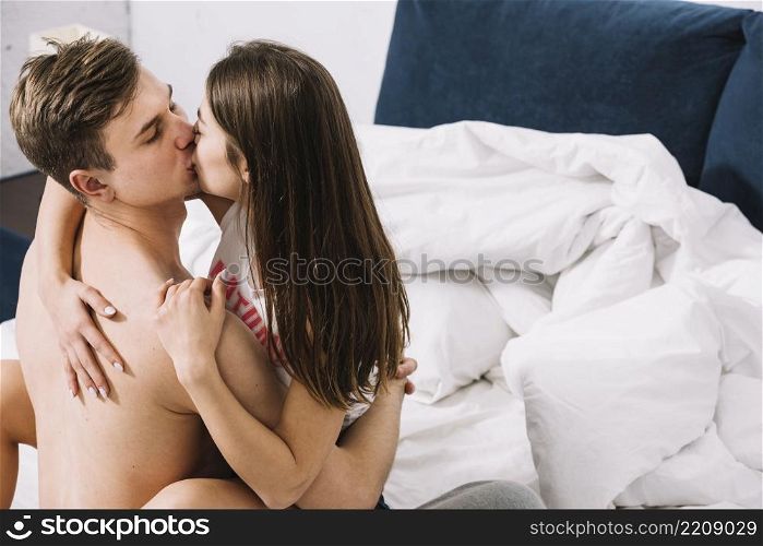young couple kissing bed