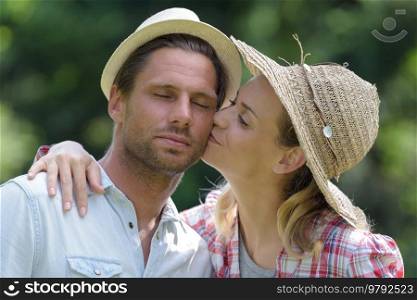 young couple kissing in the forest