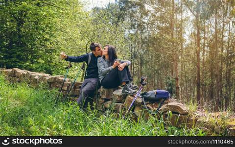 Young couple kissing while making a break to do trekking outdoors. Couple kissing while making a break to do trekking