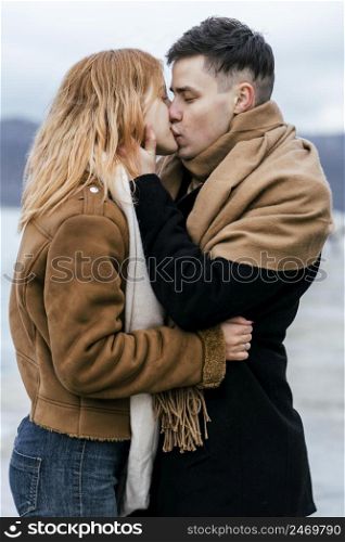 young couple kissing winter outdoors