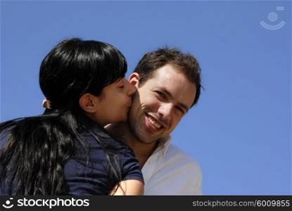 young couple kissing with the sky as background