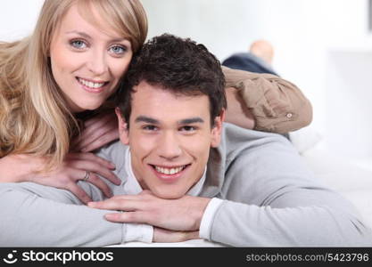 Young couple laying on bed together