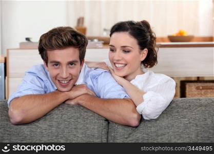 Young couple leaning on the back of their sofa