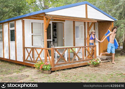 Young couple leave cabin for beach