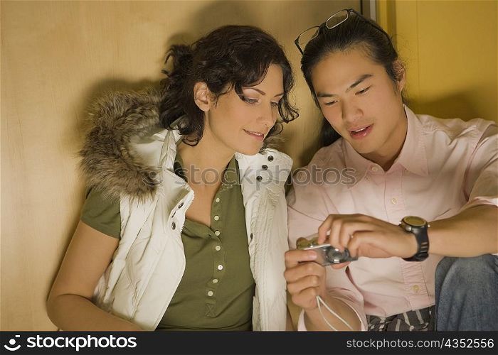 Young couple looking at a digital camera
