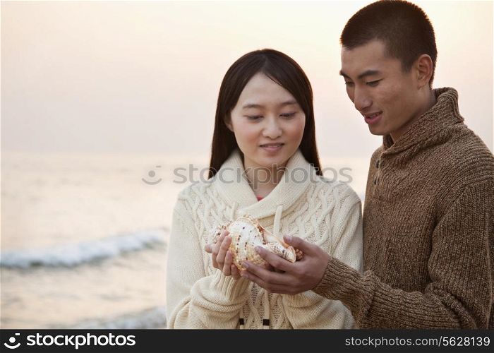 Young Couple Looking At a Seashell