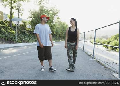 Young couple looking at each other and smiling on the road