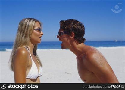Young couple looking at each other on the beach