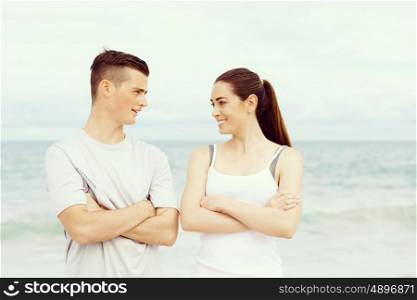 Young couple looking at each other while standing on beach. Young couple looking at each other while standing together on beach