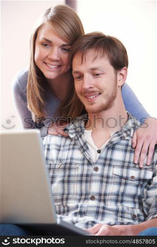 Young Couple Looking At Laptop Together