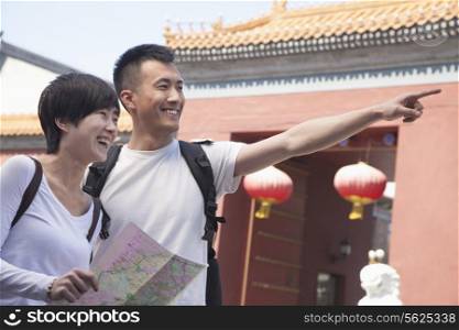 Young couple looking at map and pointing.