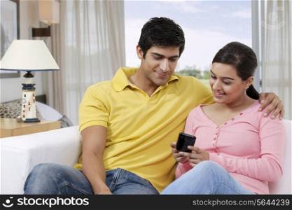Young couple looking at mobile phone together
