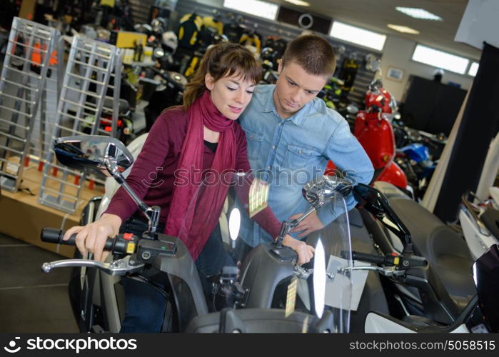 Young couple looking at new scooter