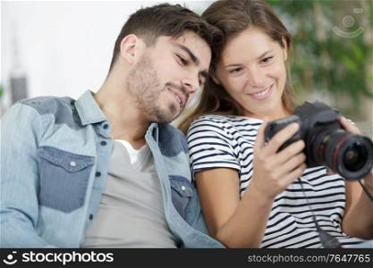 young couple looking photos on the camera