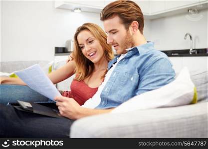 Young Couple Looking Through Personal Finances At Home