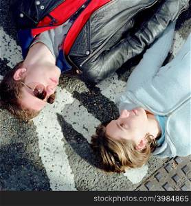 Young couple lying down on the street