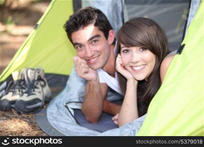 Young couple lying in a tent
