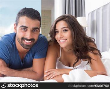 Young couple lying in bed wearing pajamas