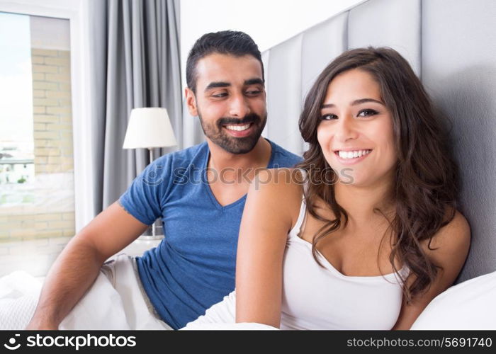 Young couple lying in bed wearing pajamas