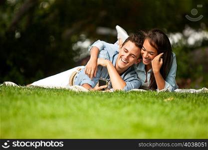 Young couple lying in park, smiling