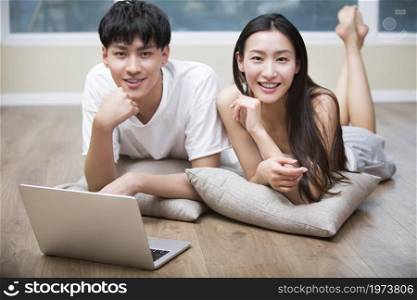Young couple lying on the floor and using a digital tablet